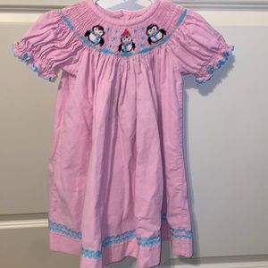 Pink corduroy smocked dress with penguins in snow